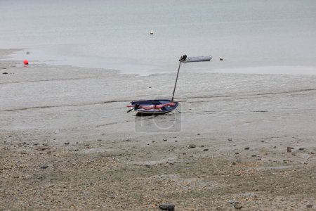 Photo for Isolated stranded boat during low tide in the town Cancale in northern France without people - Royalty Free Image
