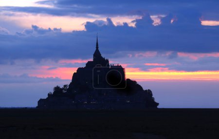 Foto de Encantadora silueta al atardecer de la abadía del Mont Saint-Michel en la costa norte de Francia - Imagen libre de derechos