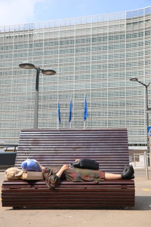 Téléchargez les photos : Bruxelles, B, Belgique - 18 août 2022 : Bureaux au Berlaymont Palace et une SDF qui dort sur le banc - en image libre de droit
