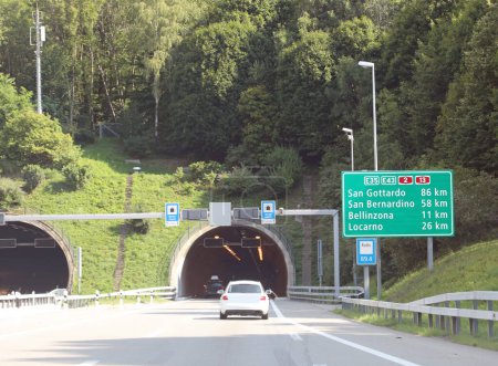 Téléchargez les photos : Tunnel et panneaux routiers sur l'autoroute avec des directions vers de nombreux endroits en Suisse - en image libre de droit