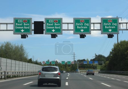 Téléchargez les photos : Détecteur de vitesse moderne et paiement de la vignette autoroutière avec panneaux routiers indiquant de nombreux endroits en Suisse - en image libre de droit