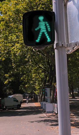 Foto de Semáforo peatonal con luz verde y hombrecito caminando cruzando la calle - Imagen libre de derechos