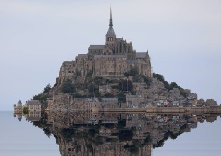 Photo for Reflection on the water of the hil with abbey of Mont Saint Michel in France - Royalty Free Image