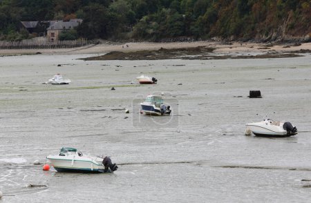 Photo for Many boats and motorboats beached during low tide in the town of Cancale in Brittany in France - Royalty Free Image