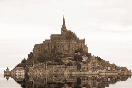 Photo for Reflection on the water of abbey of Monte Saint Michel in Northern France with sepia toned effect - Royalty Free Image