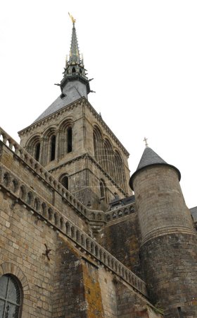 Foto de Vista desde abajo del campanario con la estatua de oro del arcángel Miguel en la Abadía del Mont Saint Michel en el norte de Francia - Imagen libre de derechos