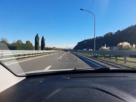 Téléchargez les photos : Large autoroute gratuite avec tableau de bord de voiture au premier plan lors d'un voyage - en image libre de droit