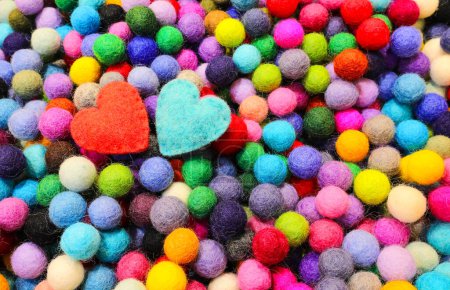 Foto de Muchas bolas de lana de fieltro tallada y dos corazones azules y rojos - Imagen libre de derechos