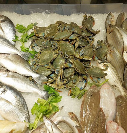 Téléchargez les photos : Beaucoup de crabes bleus très frais sur le comptoir plein de glace à vendre dans les poissonneries et plus de poissons - en image libre de droit