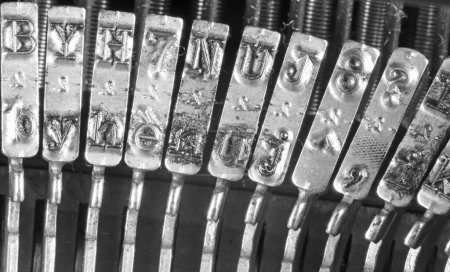Téléchargez les photos : Détail de la machine à écrire en acier inoxydable marteau avec des lettres en relief en noir et blanc - en image libre de droit