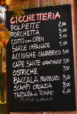 Téléchargez les photos : CICCHETTERIA signifie Snack-bar en italien et liste des aliments de cuisine italienne signifiant boulettes de viande porchetta pané sardines anchois huîtres morue et autres plats - en image libre de droit