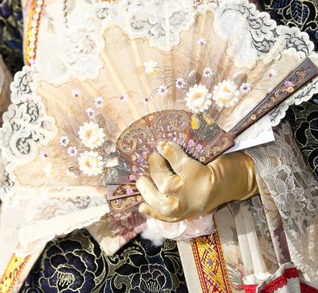 Téléchargez les photos : Noble Femme avec la robe luxueuse tout en aérant avec le ventilateur tenu par une main - en image libre de droit