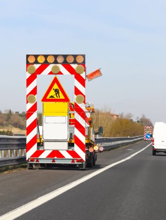camión y la carretera funciona en la autopista sin trabajador y los signos italianos que significa HOMBRES EN EL TRABAJO Reducir la velocidad
