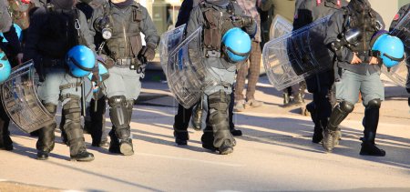 Polizisten in Krawallausrüstung während der Protestdemonstration mit Helmen unterwegs