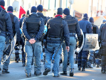 Téléchargez les photos : Police en tenue anti-émeute lors de la manifestation de protestation avec des casques sur la route - en image libre de droit