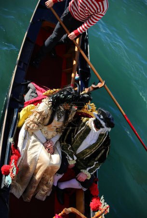 Photo for Venice, VE, Italy - February 13, 2024: married couple with very luxurious historical costumes on the gondola during the Venetian carnival - Royalty Free Image