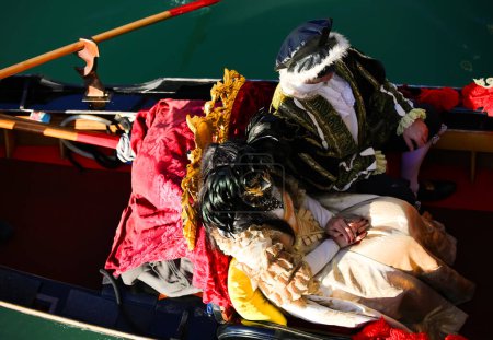 Photo for Venice, VE, Italy - February 13, 2024: married couple with historical costumes on the gondola during the Venetian carnival - Royalty Free Image