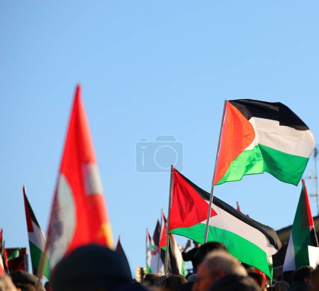 many waving palestine flags with protesters during peaceful demonstration for peace