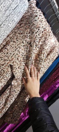 hand of a young girl choosing a trendy blouse in the casual clothes store of the mall