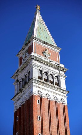 Detail der Spitze des hohen Glockenturms von San Marco auf dem berühmten Platz von Venedig in Italien mit blauem Himmel