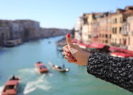Photo for Thumb up ok sign of hand with fingers with red nail polish in Venice city over grand canal with boats - Royalty Free Image