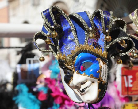 Narrenmaske mit Rasseln in venezianischem Verkaufsstand in Italien zu verkaufen