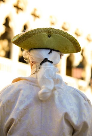 nobleman and wig of the masked man during the Venice Carnival celebrations in Italy and the palace in background
