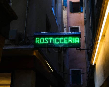 green illuminated sign with the writing ROSTICCERIA which means rotisserie in Italian