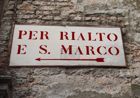 altes Straßenschild in der Mauer in Venedig in Italien mit Schriftzug auf der Rialto-Brücke oder auf dem Markusplatz