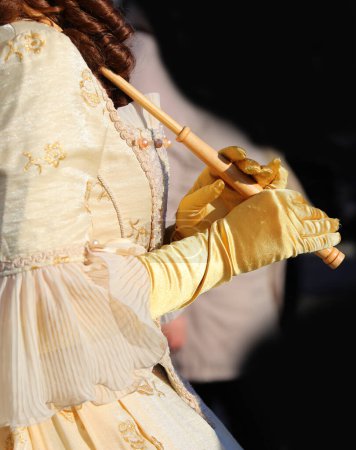 Photo for Hands of girl with silky yellow gloves holding the handle of the umbrella dressed in historic nineteenth-century dress - Royalty Free Image