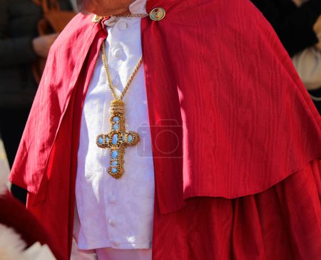 bishop wearing a cassock with the Christian cross inlaid with precious gems during the religious ceremony