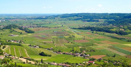 wide view from above of the plain with cultivated fields and some farms