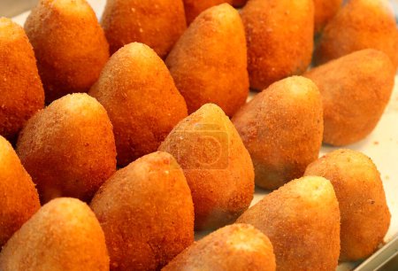 Téléchargez les photos : Golden fried food appelé arancini ora ARANCINE en langue italienne rempli de riz légumes viande ou fromage en vente dans un étal de marché en Sicile - en image libre de droit