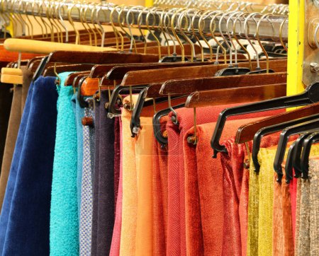 Photo for Clothes and fabrics neatly arranged on a hanger in a clothes shop - Royalty Free Image
