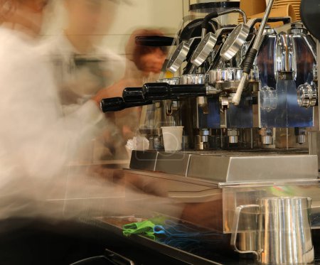 Foto de Cafetera espresso en un bar de la estación de tren con siluetas borrosas de baristas debido al uso de una técnica de larga exposición - Imagen libre de derechos