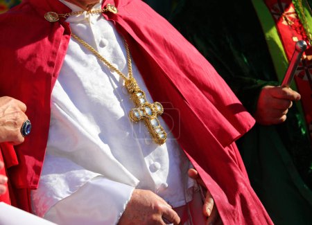 Kardinalbischof trägt während der religiösen Zeremonie eine Soutane mit dem großen christlichen Kreuz, in das kostbare Edelsteine eingelassen sind