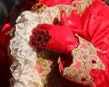 red glove with ring and elegant late nineteenth-century dress of the person disguised during the carnival festivals in Venice