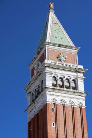 Detail der Spitze des hohen Glockenturms von San Marco auf dem berühmten Platz von Venedig in Italien mit blauem Himmel
