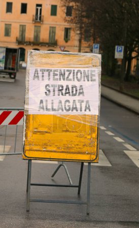 Großes Warnschild mit großem Schriftzug ATTENZIONE STRADA ALLAGATA in italienischer Sprache, was überflutete Straßen bedeutet
