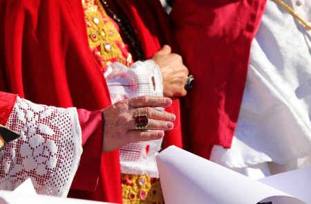 Hand des Priesters mit einem Ring mit einem roten Rubin, während er den Gläubigen während des religiösen Ritus den Segen erteilt