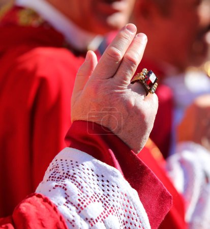 Hand des Priesters mit einem Ring mit einem großen roten Rubin bei der Segnung der Gläubigen während des religiösen Ritus