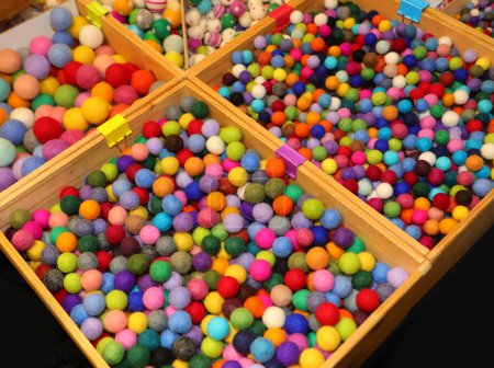 bandejas llenas de bolas de colores hechas de lana hervida de varios tamaños a la venta en la tienda de pasatiempos y pasatiempos
