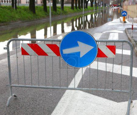 Straßenschild mit Umleitungspfeil, weil die Straße nach dem Hochwasser komplett überflutet ist