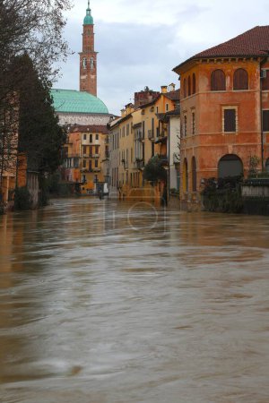 Fluss während der Überschwemmungen in der Stadt Vicenza und Norditalien und im Hintergrund die berühmte Basilika Palladiana, Symbol der Stadt