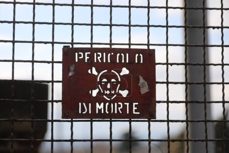 Téléchargez les photos : Signe de fer avec l'écriture en italien Pericolo di Morte qui signifie danger de mort si l'on passe la barrière de protection - en image libre de droit