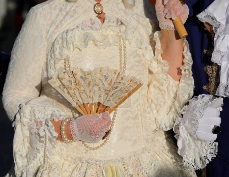 Noblewoman dans une robe blanche décorée de luxe tenant un ventilateur