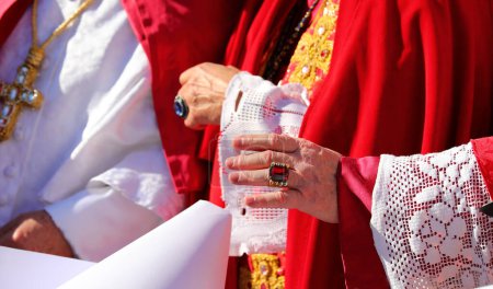 Hand eines Bischofs in geistlicher Kleidung, der die Gläubigen während eines religiösen Ritus segnet