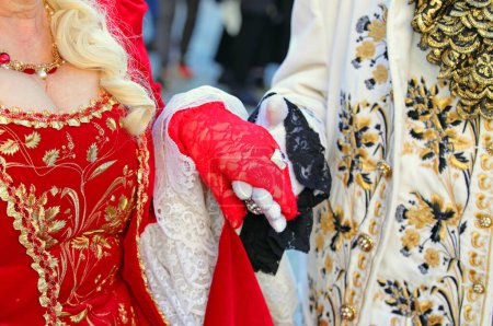 Par de nobles amantes sosteniendo las manos en ropa aristocrática antigua y lujosa durante el baile de máscaras