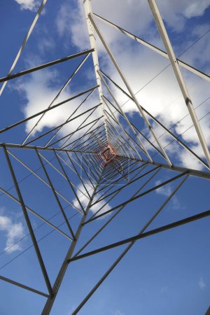 High Voltage Electricity Grid Pylon seen from below  and white clouds