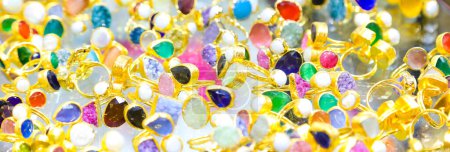 Photo for Background of many golden rings with colored stones for sale in the window of the jewelry store - Royalty Free Image